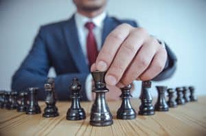 Crypto trading strategies: entrepreneur holding a chess piece